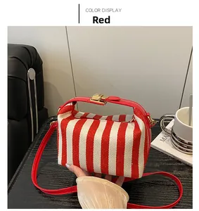 Detail der rot-weiß gestreiften Segeltuchtasche mit Ledergriff und Metallverschluss
