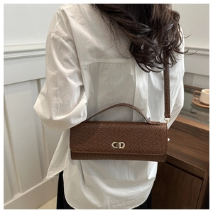 Brown woven texture crossbody bag shown on shoulder with gold CD buckle detail