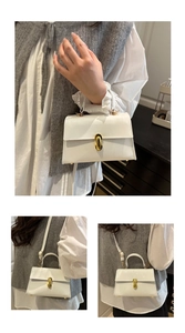 Detail view of white high-gloss handbag with gold metal lock and long shoulder strap