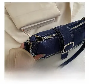 Details des glatten Metallreißverschlusses und der silbernen Kette der Jeans-Tasche