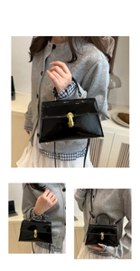 Close-up of black patent leather crossbody bag featuring a gold metal lock and handle