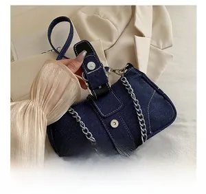Detail der blauen Denim Baguette-Tasche mit Silberkette und weißen Kontrastnähten