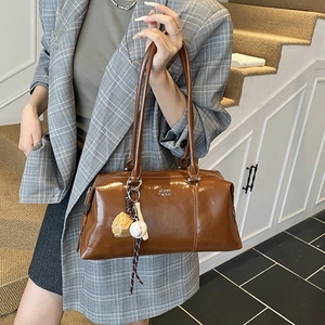 Retro brown glossy leather bowling bag with baseball charms and stylish shoulder strap