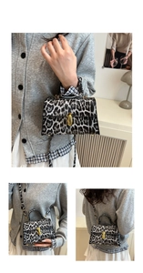 Detail view of stylish snow leopard print handbag featuring gold metallic lock and strap