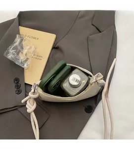 Capacity test of cream leather crossbody bag with knot strap and silver zipper detail
