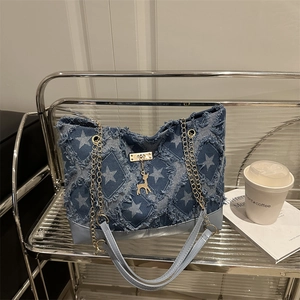 Sac cabas en denim à motif d'étoiles avec chaîne dorée et breloque cerf sur présentoir