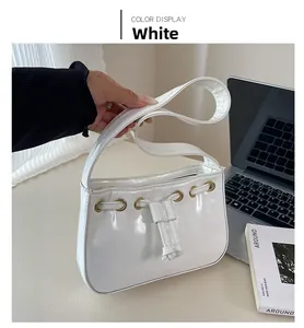Close-up of a white glossy underarm bag featuring golden eyelets and drawstring details