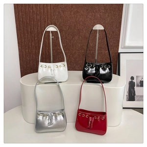 Detail of four stylish mini tote bags in glossy white, black, red, and silver finishes