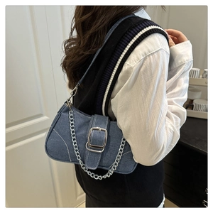 Detailansicht der Denim-Schultertasche mit Silberschnalle und Kette im Retro-Stil