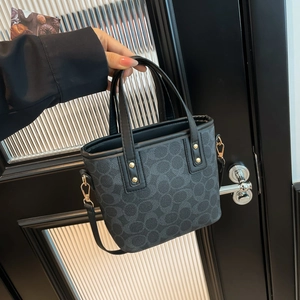 Schicke schwarze Monogramm-Beuteltasche mit Ledergriffen und goldenen Beschlägen