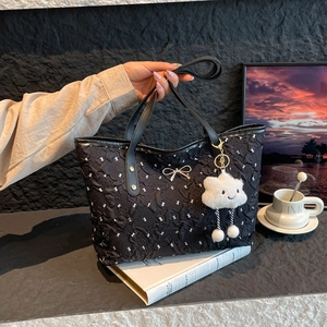 Minimalist black tote bag in bubble fabric with white bow patterns and cloud charm