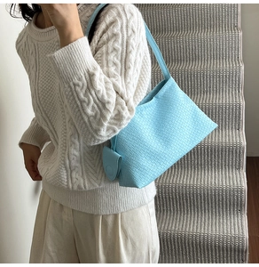 Detail einer hellblauen Hobo-Bag mit Webmuster und passendem runden Münzetui-Anhänger