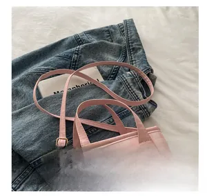 Detail of pink plaid pattern on PU leather crossbody bag with adjustable shoulder strap