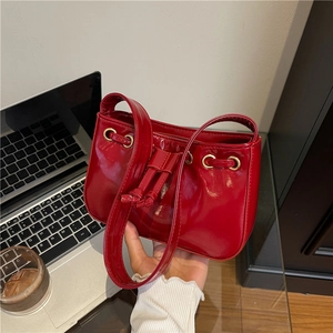Glossy red patent leather square handbag with drawstring details and gold metal eyelets