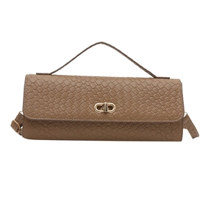 Sac à main marron avec texture tressée, boucle dorée et bandoulière sur fond blanc uni
