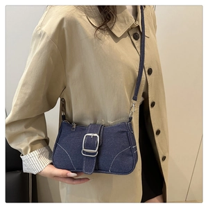 Detail of vintage denim crossbody bag with contrast stitching and silver buckle accent