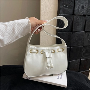 Minimalist white semi-moon shoulder bag with golden eyelets and leather drawstring detail