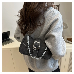 Detail view of denim crossbody bag with silver square buckle and metallic chain strap