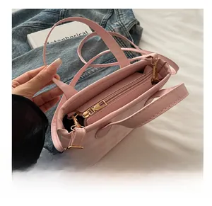 Detail of pink plaid tote bag featuring a smooth gold zipper and inner pocket storage