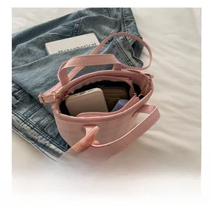 Detail view of pink plaid bucket bag showing large interior capacity with a phone and wallet