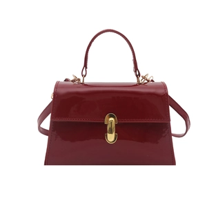 Sac à main en cuir verni rouge brillant avec boucle capsule dorée et bandoulière