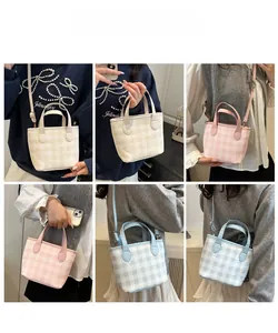 Detail view of plaid patterned crossbody bags in white, pink and blue pastel colors