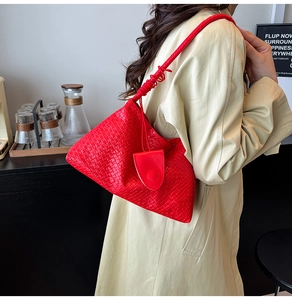 Detail of red woven leather tote bag with pleated handle and matching mini pouch accessory