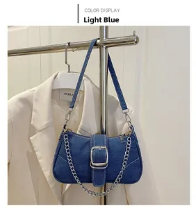 Detailansicht der hellblauen Denim-Schultertasche mit Metallschnalle und Kettengurt