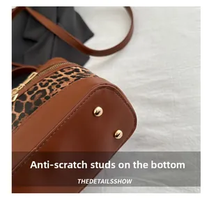 Detailed close-up of leopard print bucket bag base with protective gold metal feet studs