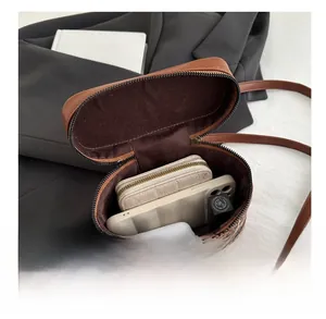 Spacious interior of leopard print bucket bag holding wallet, phone and cosmetics
