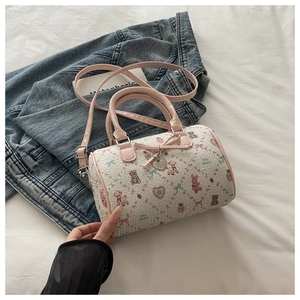 Gros plan d'un sac Boston blanc avec motifs animaux roses et détail de nœud en métal