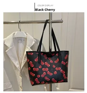 Detail of a black cherry tote bag with red fruit patterns on a premium hanger