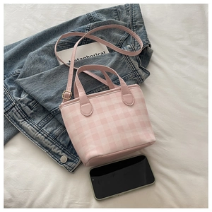Close-up of pink checkered mini tote bag showing compact size next to a smartphone