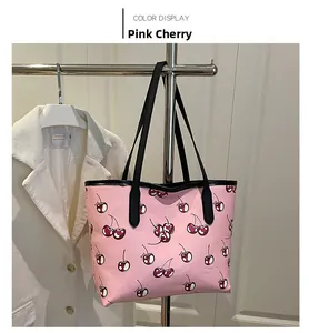 Detailed side view of pink tote bag with cherry print hanging next to a white coat