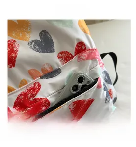 Detail of backpack front zip pocket with vintage heart print storing a smartphone