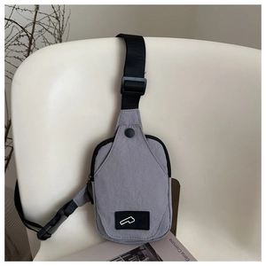 Detail showing the gray nylon texture, adjustable strap, and logo label of this chest bag