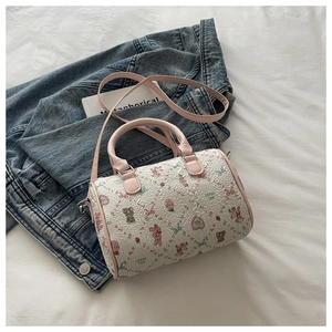 Détail du sac Boston crème avec motifs d'ours roses sur une veste en jean
