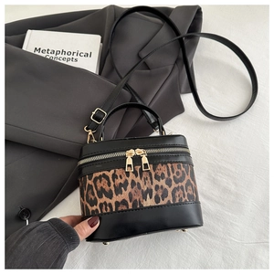Detail of leopard print bucket bag with gold zippers and premium leather stitching