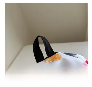 Detail of reinforced black strap handles on a white bag with colorful heart prints