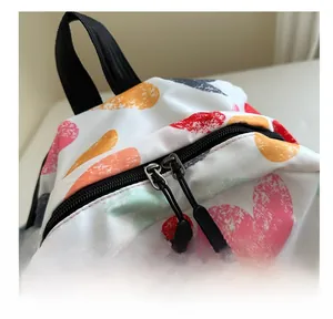 Detail showing smooth double zipper closure with black rubber pullers on graffiti backpack