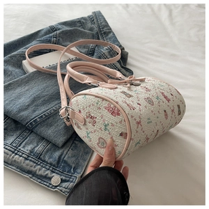 Détail du sac Boston à motifs d'ours roses posé sur du denim et du linge blanc
