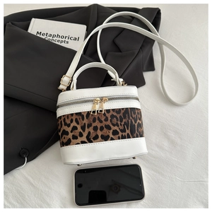 Mini leopard print bucket bag with gold zippers and phone for scale reference