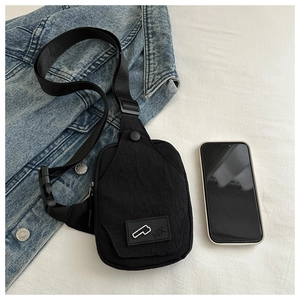Macro view of compact black nylon sling bag with adjustable strap for smartphone storage