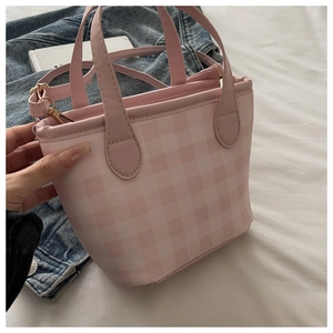 Detail of pink and white checkered handbag with gold metal hooks and detachable strap