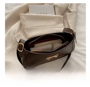 Macro shot of dark brown shoulder bag interior with multiple compartments and zipper pocket