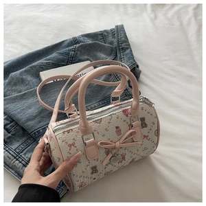 Détail du sac Boston avec imprimés ours fleuris et nœud rose sur fond denim blanc