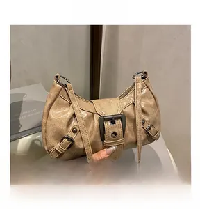 Detail of vintage beige shoulder bag featuring metal buckle and pleated leather texture