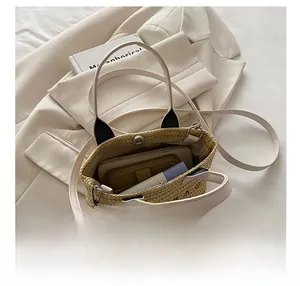 Detail view of the straw tote bag showing large capacity interior and magnetic closure
