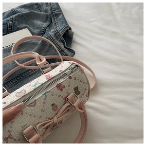 Détail du sac Boston avec motif d'ours rose et texture sur cuir PU blanc gaufré
