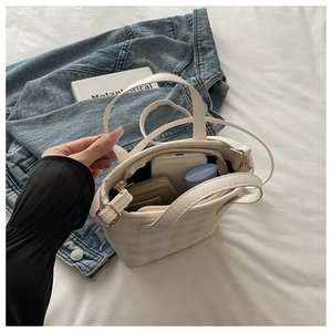 Internal view of beige checkered handbag showing phone, wallet and cosmetics storage